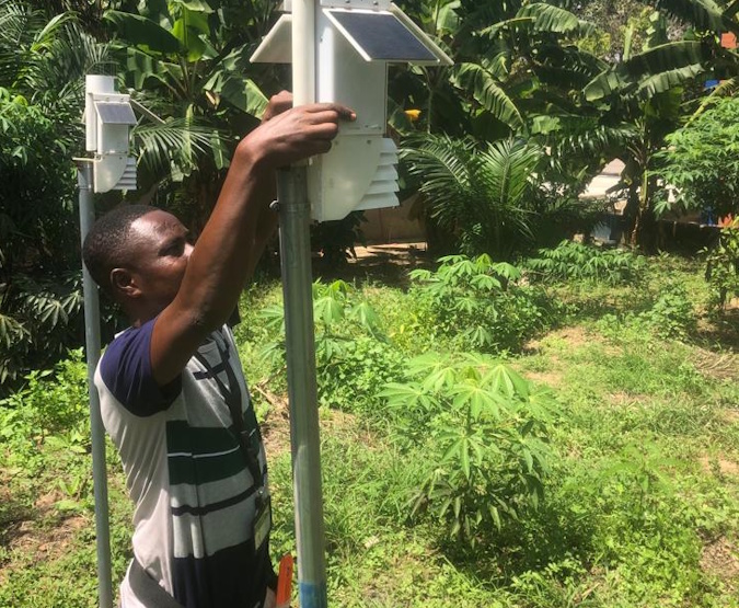 Technician servicing a Veriground weather station in San Pedro on a pole